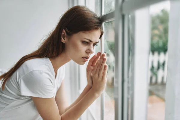 Smutna kobieta wyglądająca przez okno na domową depresję — Zdjęcie stockowe