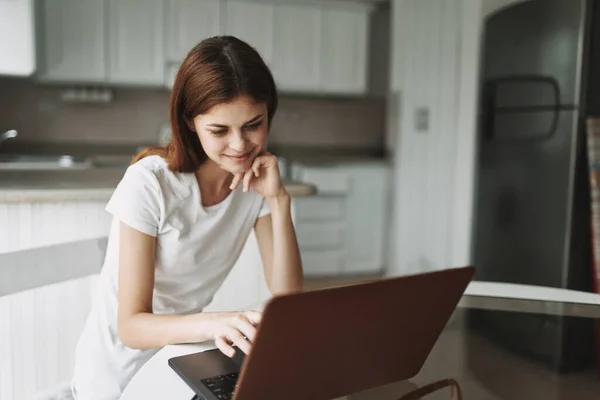 Mujer delante de la computadora portátil en casa comunicando internet —  Fotos de Stock