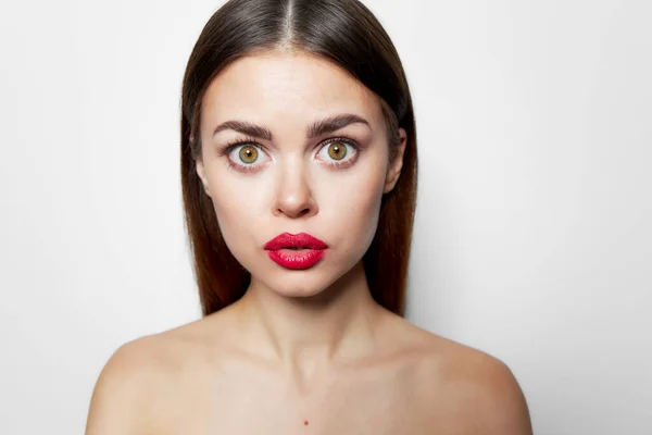 Woman with surprised facial expression red lips bared shoulders cropped