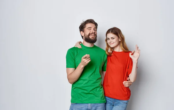 Emocjonalny mężczyzna i kobieta w kolorowe t-shirty rodzinne styl życia studio — Zdjęcie stockowe