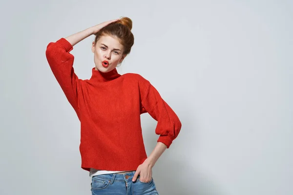손을 흔들며 빨간 스웨터를 입고 있는 여자가 카피 스페이스를 보고 있다. — 스톡 사진