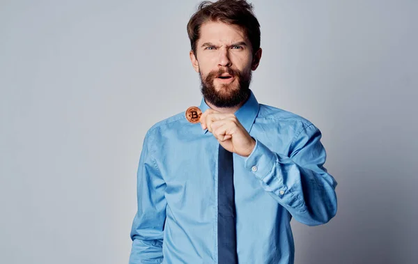 Geschäftsmann im blauen Hemd mit einer Münze in der Hand — Stockfoto