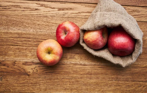 成熟的苹果在袋子里，放在木制桌布上，背景图像，水果产品 — 图库照片