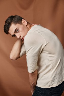 Bir adam fotoğraf için poz veriyor şık bir saç stili, yakın çekim çekici bir görüntü.