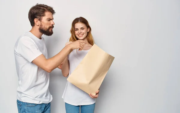 Familia joven en camisetas blancas paquete con compras viaje aislado fondo — Foto de Stock