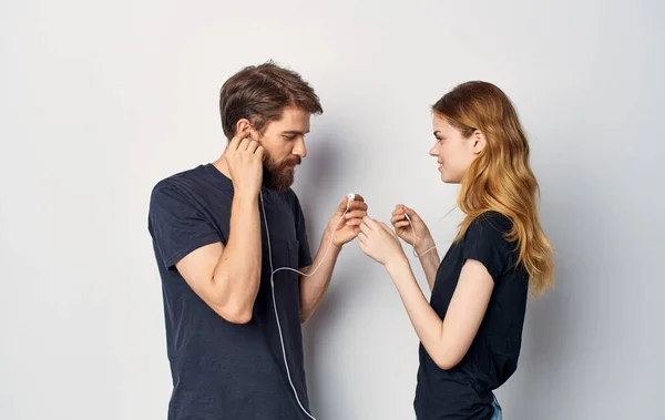音楽技術のライフスタイルを聞くヘッドフォン付きの黒いTシャツを着た若いカップル — ストック写真