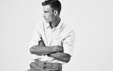 Siyah ve beyaz bir fotoğraf. Yakışıklı bir adamın elleri açık bir arka planda hareket ederken çekilmiş.