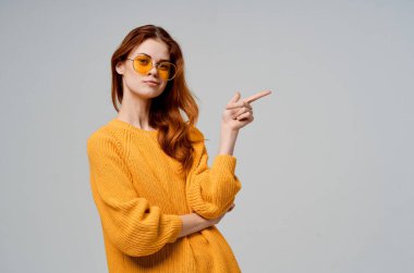 Sarı süveter giyen güzel bir kadın, modaya uygun giyiniyor.