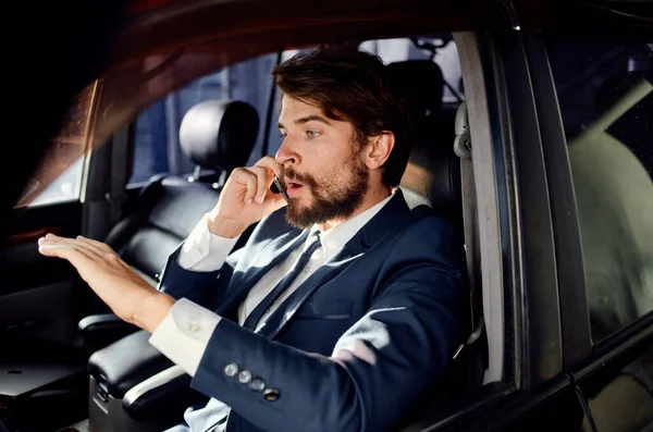 business man in a suit talking on the phone in a car finance model