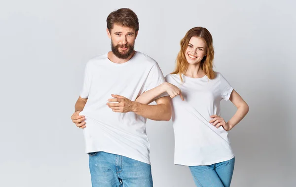 Uomo emotivo in una t-shirt e una donna in jeans su uno sfondo leggero tessuto abbigliamento moda stile — Foto Stock