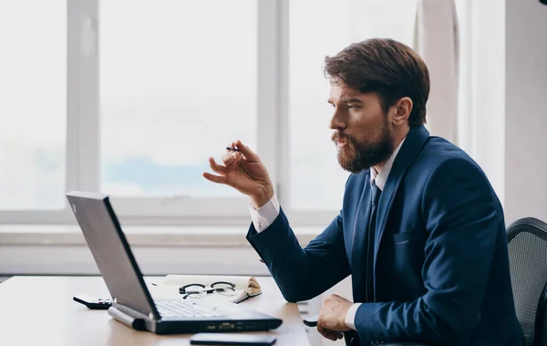 Homem de negócios intrigado olha para o laptop na mesa no escritório modelo de escritório — Fotografia de Stock