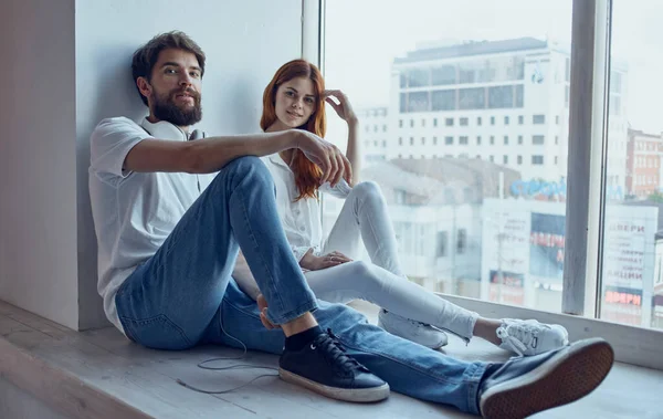 Junges Paar sitzt auf der Fensterbank in der Nähe der Fensterbank — Stockfoto