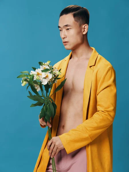 セクシーなアジア人男性で黄色コートヌード胴と白い花休日ギフト — ストック写真