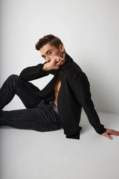 검은 재킷 현대 스타일의 고급 스튜디오 바닥에 앉아 있는 남자 — 스톡 사진