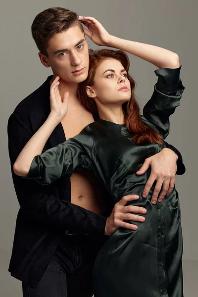 Ένας άντρας σε ένα ξεκούμπωτο μαύρο πουκάμισο και μια σέξι γυναίκα σε ένα φόρεμα περικοπή άποψη — Φωτογραφία Αρχείου