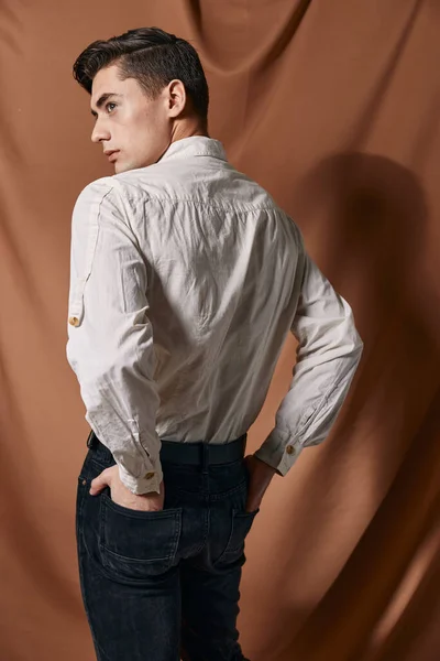 Άνδρας σε λευκό πουκάμισο στέκεται με την πλάτη του casual ρούχα Studio φόντο ύφασμα — Φωτογραφία Αρχείου