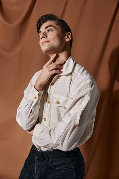 Um homem de camisa branca ajusta seu colarinho de estúdio de autoconfiança — Fotografia de Stock