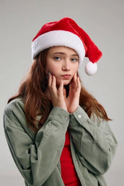 Portrait d'une belle fille dans un chapeau de fête Noël Nouvel An geste avec ses mains — Photo