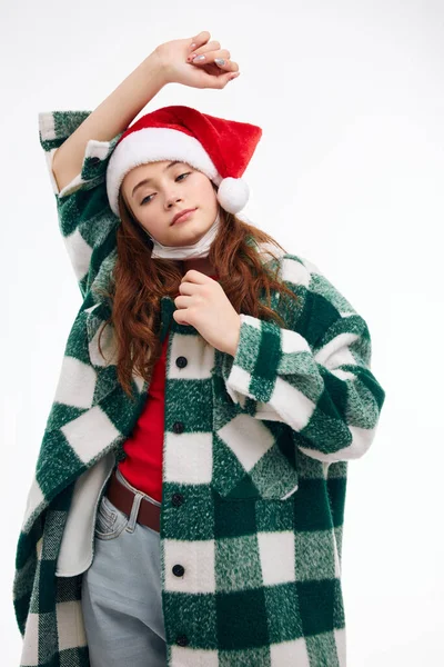 Elini başının üstünde tutan bir kadın Noel kıyafetleri stüdyo ışık arka planı — Stok fotoğraf