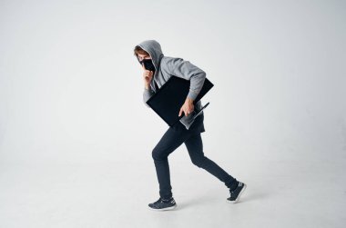 Başında kapüşonlu gizli bir adam bilgisayar monitöründe hırsızlığı izliyor.