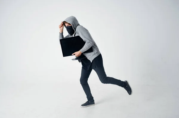 Чоловік у сірому светрі маскує крадіжку техніки хакер — стокове фото
