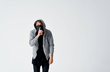 Siyah maskeli bir erkek hacker ve arka planda hafif bir hırsızlık olayı.