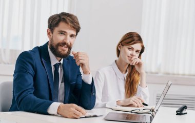 İşadamı ve çalışanı laptopta iş belgeleriyle ofiste.