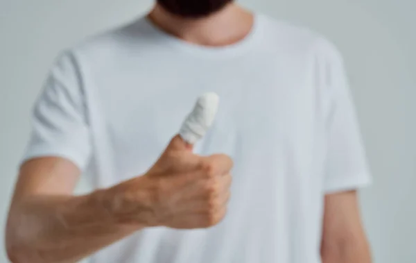 Hombre en camiseta blanca vendado pulgar problemas de salud medicina —  Fotos de Stock