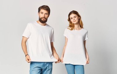 Birebir aynı tişörtleri giyen bir kadın ve erkeğin portresi.