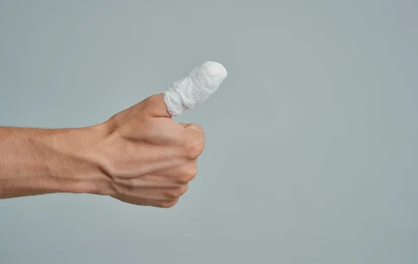 Hombre en camiseta blanca roto dedo vendado medicina —  Fotos de Stock