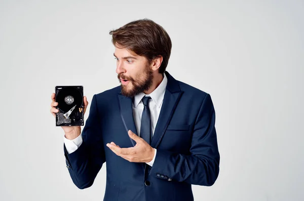 Hombre de negocios emocional en un traje gesto con las manos y el disco duro desmontado — Foto de Stock