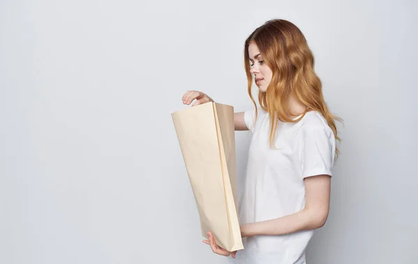 Cheerful woman in a white T-shirt with a package in her hands Shopping — Stock Photo, Image