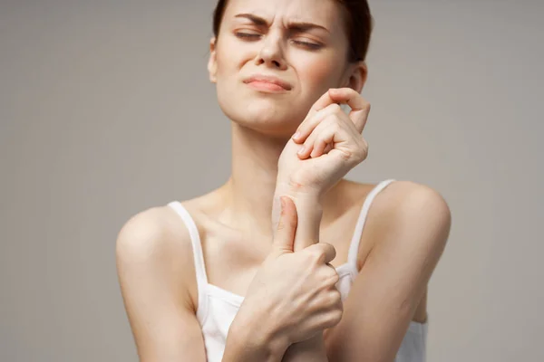 Ung kvinna gestikulerande med händer handled smärta upprörd utseende — Stockfoto