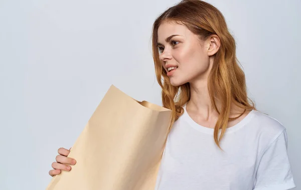 Cheerful woman in a white T-shirt with a package in her hands Shopping — Stock Photo, Image