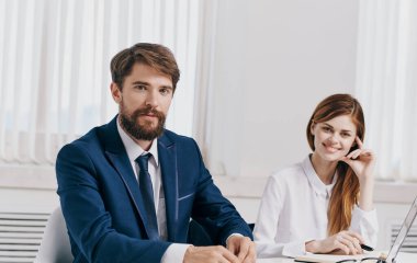 İşadamı ve çalışanı laptopta iş belgeleriyle ofiste.