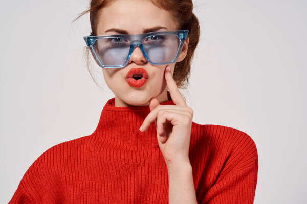 emotional woman with blue glasses on her face bright makeup red sweater