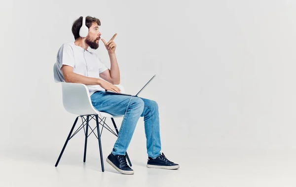 Homem com fones de ouvido na frente do laptop sentado no escritório de tecnologia de comunicação cadeira — Fotografia de Stock