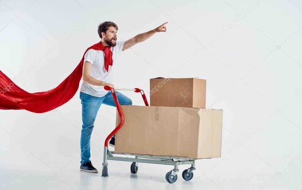 courier in red cloak superhero cardboard boxes and cargo trolley