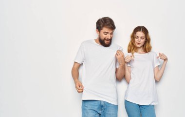 Aynı tişörtleri giyen erkek ve kadın açık arka planda kot pantolon, aile tarzı moda.