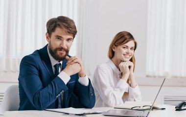Ofisteki masada dizüstü bilgisayarı olan iş adamı ve kadın.