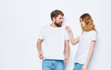 Aynı tişörtleri giyen erkek ve kadın açık arka planda kot pantolon, aile tarzı moda.