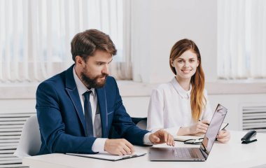 İşadamı ve çalışanı laptopta iş belgeleriyle ofiste.