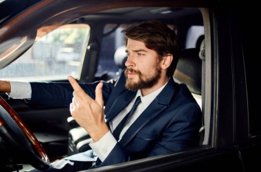 Takım elbiseli yakışıklı bir adam araba kullanıyor. Resmi yaşam tarzı.