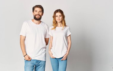 Kot pantolon ve tişört giyen bir erkek ve bir kadın elleriyle jest yapıyor. Eğlenceli duyguları kopyala uzay.