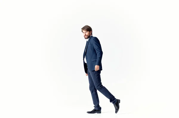 Homme d'affaires en costume et chaussures marche sur le côté sur un fond clair Espace de copie — Photo