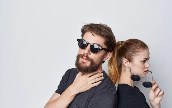 Mladý pár nošení sluneční brýle móda ležérní oblečení studio romantiku izolované pozadí — Stock fotografie