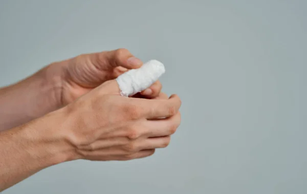 Zabandażowany kciuk problemy zdrowotne pacjent medycyna pojedyncze tło — Zdjęcie stockowe