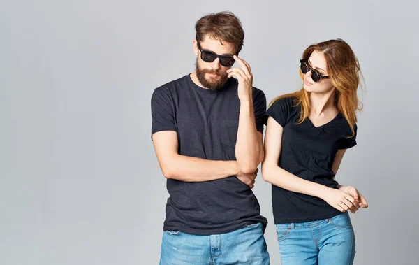 Молодая пара в черных футболках солнцезащитные очки студийный романтический стиль общения — стоковое фото