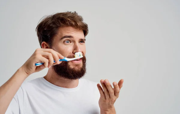 Elinde diş fırçası olan bir adam ağız bakımı sabah prosedürleri kar beyazı gülümseme — Stok fotoğraf