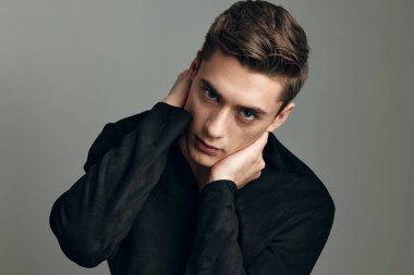 Yakışıklı, modaya uygun, siyah gömlekli elleri baş çekici stüdyo tipi.